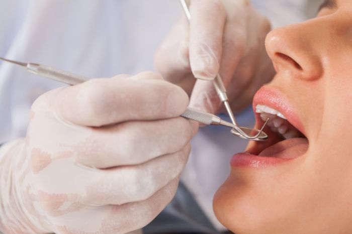 患者の口の中をチェックする歯科医