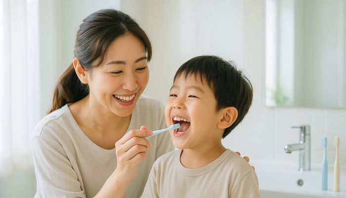 母親が子どもの歯磨きを手伝う様子、子どものむし歯予防と正しい歯磨き習慣